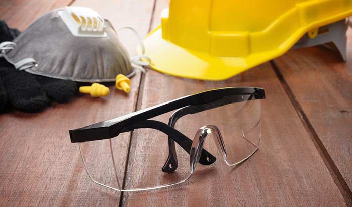 Safety gear for bridge workers, including a hard hat, goggles, earplugs and respiratory protection.