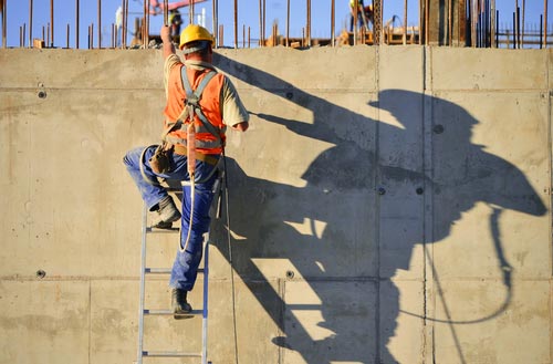 Construction worker on a ladder that complies with OSHA guidelines