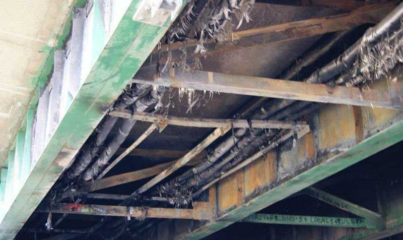 Man-caused fire damage to under-bridge utilities.